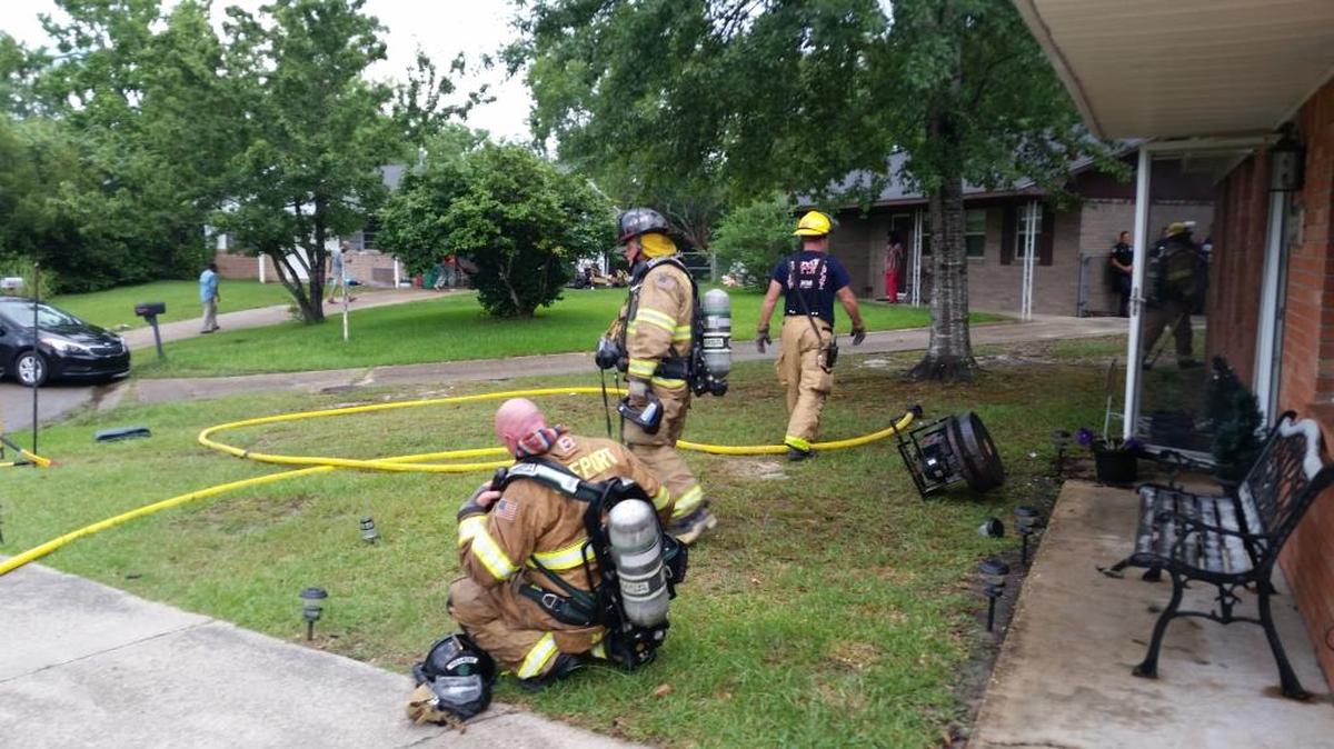 Gulfport firefighters work on a home in the 3100 block of Kimberly Drive in Gulfport on Sunday afternoon. A lightning strike caused an attic fire while the homeowner was away, and neighbors called the fire department.