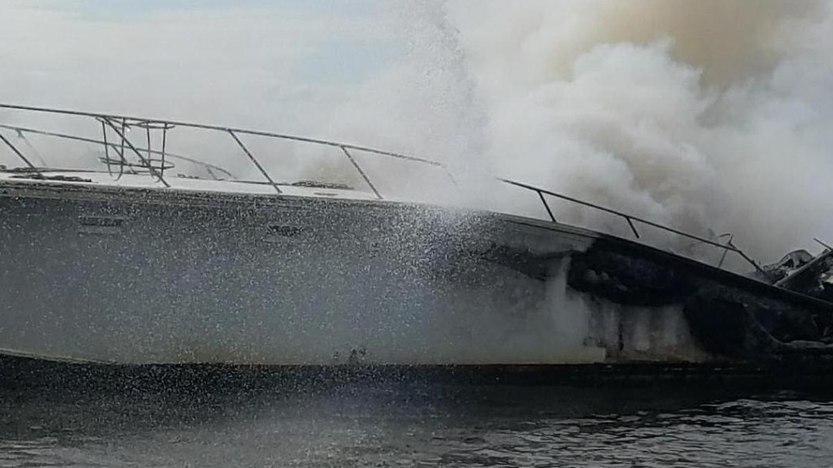 Streams of water from a Biloxi Fire Department fire boat spray over a burning yacht that caught fire Friday south of Grasshopper Island on Biloxi's Back Back.