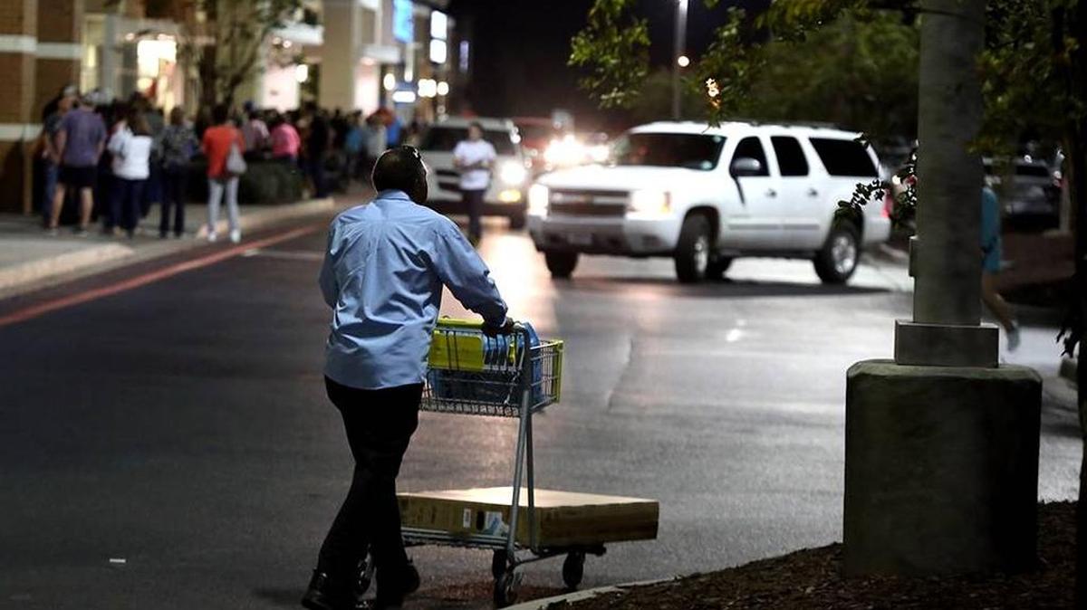 A man wheels his purchases to his car while shoppers wait in line for Dick's Sporting Goods and Kohl's to open at The Promenade in November 2015. D’Iberville police will beef up patrol this year to ensure safety.