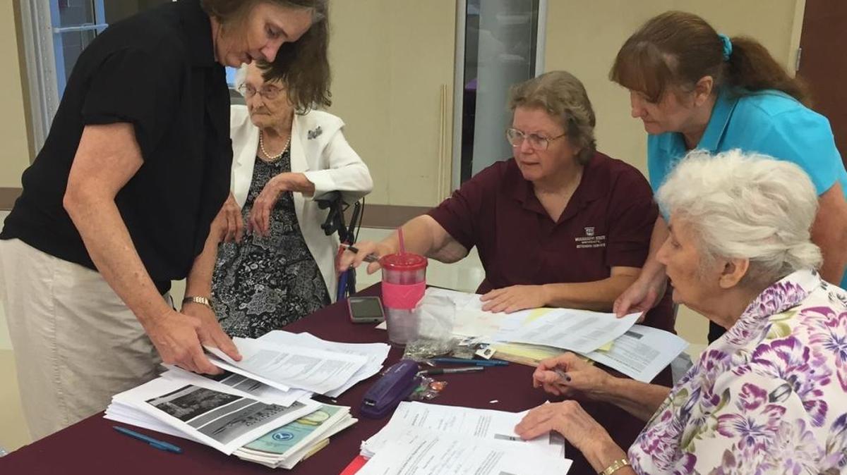Roseanne McConnell, Doris Weems, Lynn Grier, Diane Conn and Francis Powell register exhibits for the Harrison County Fair on Tuesday at the hurricane shelter on County Farm Road.