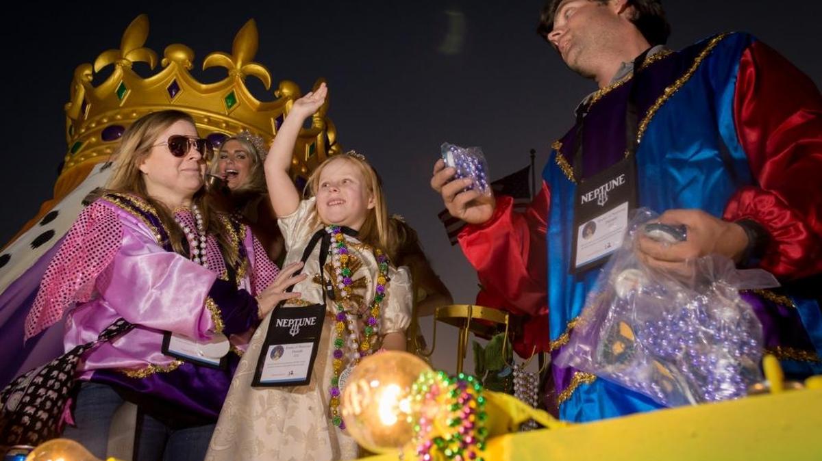 Sophia Myers, designated Princess of Neptune, waves at revelers in downtown Biloxi during the Krewe of Neptune night parade on Feb. 25, 2017.