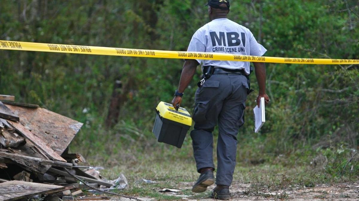 Terrence Packer with the Mississippi Bureau of Investigations crime lab crosses the crime scene tape where a body was discovered in a Bay St. Louis neighborhood in March 2009.