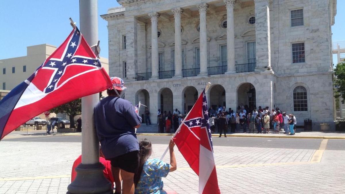 Mississippi flags wave across the street from Biloxi City Hall, where a prayer rally was held on the steps Tuesday by those who want the state flag to remain down at city buildings.