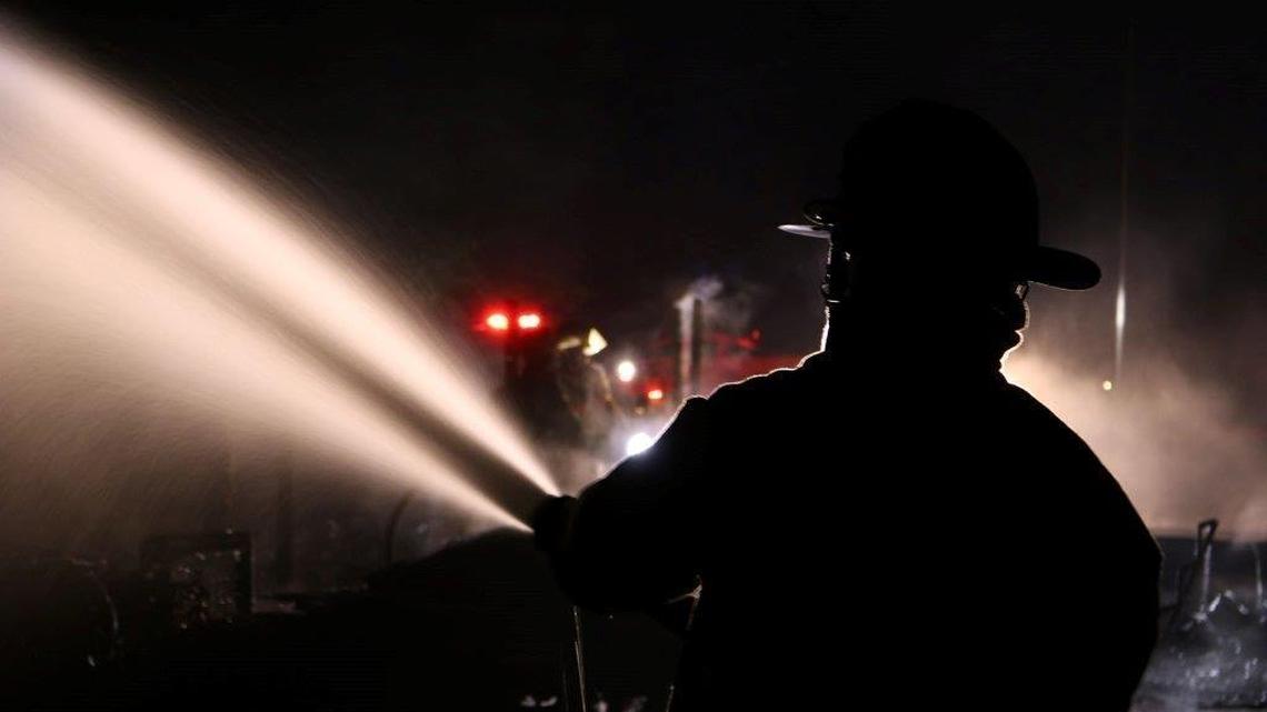Firefighters blast water to put out a Saturday night fire that destroyed a camper trailer and boat on West Early Wynn Drive in north Harrison County.