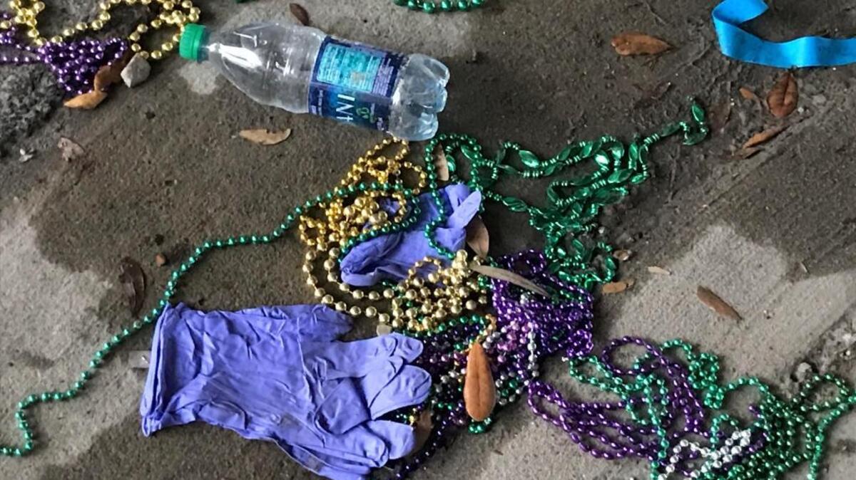 First responder's glove lie among Mardi Gras beads on Howard Avenue where a man died after falling off a truck while watching the GCCS parade in Biloxi.