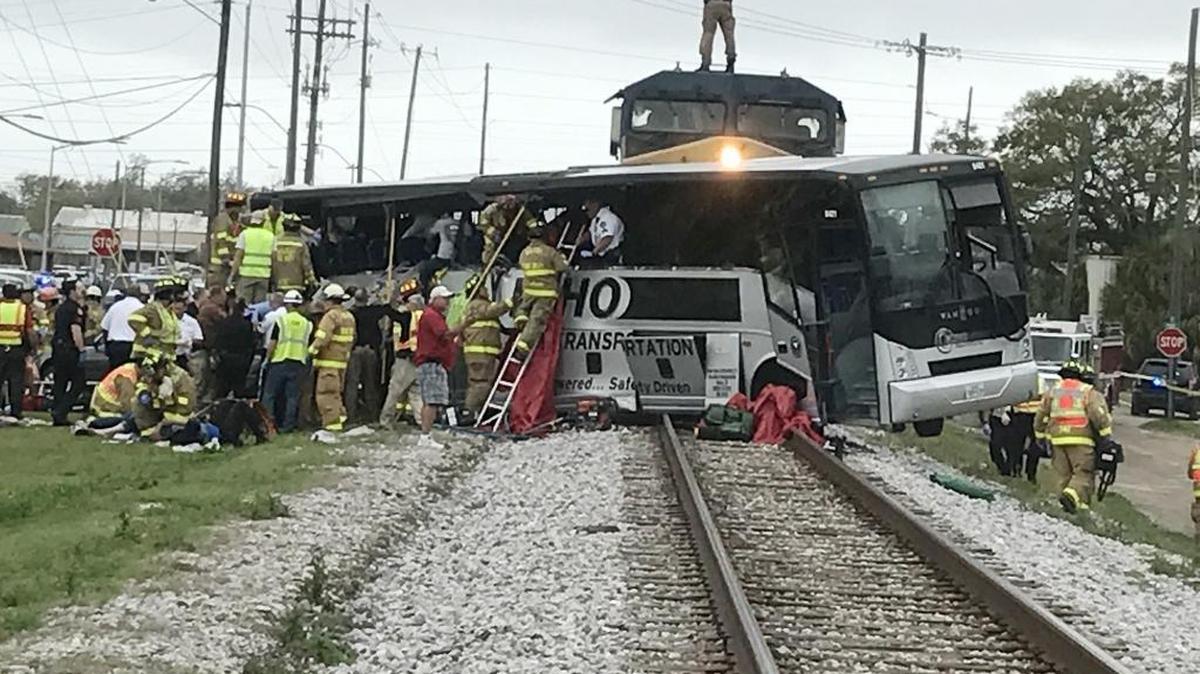 Firefighters and paramedics work to remove passengers from a charter bus that was hit by a CSX train at the Main Street crossing in Biloxi, Miss. on Tuesday, March 7, 2017.