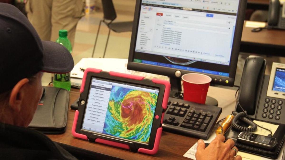 An American Medical Response emergency medical technician looks at a satellite image of Hurricane Isaac at the Hancock County Emergency Operations Center on Aug. 28, 2012.