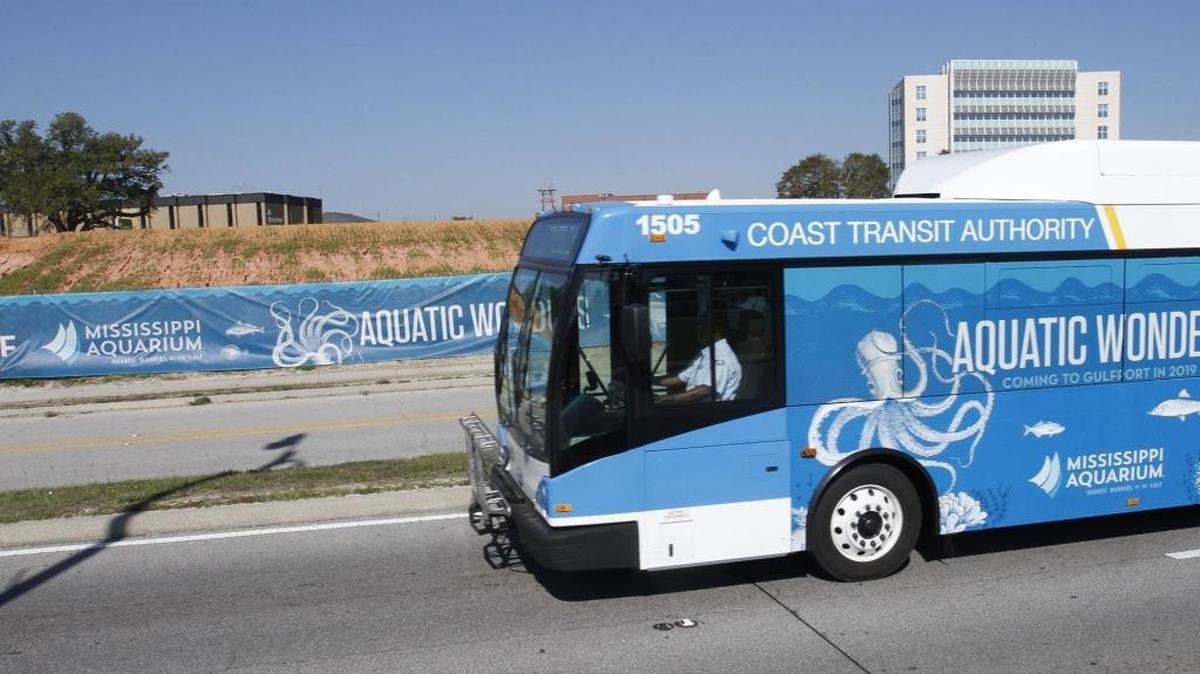 A Coast Area Transit bus advertising the Mississippi Aquarium drives past the site in downtown Gulfport on Thursday. The city opened bids Thursday afternoon for the aquarium's construction.