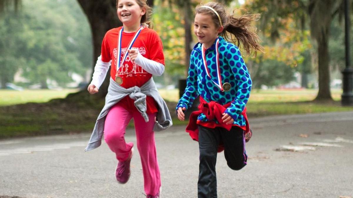 Mary Schmidt, left, and Julia Henry, students at St. Andrew's Episcopal School in New Orleans, participate in a fun run. The school holds the Cardinal Cardiac Challenge each year, selecting someone who needs their support. They raise money but also offer encouragement to the beneficiary.