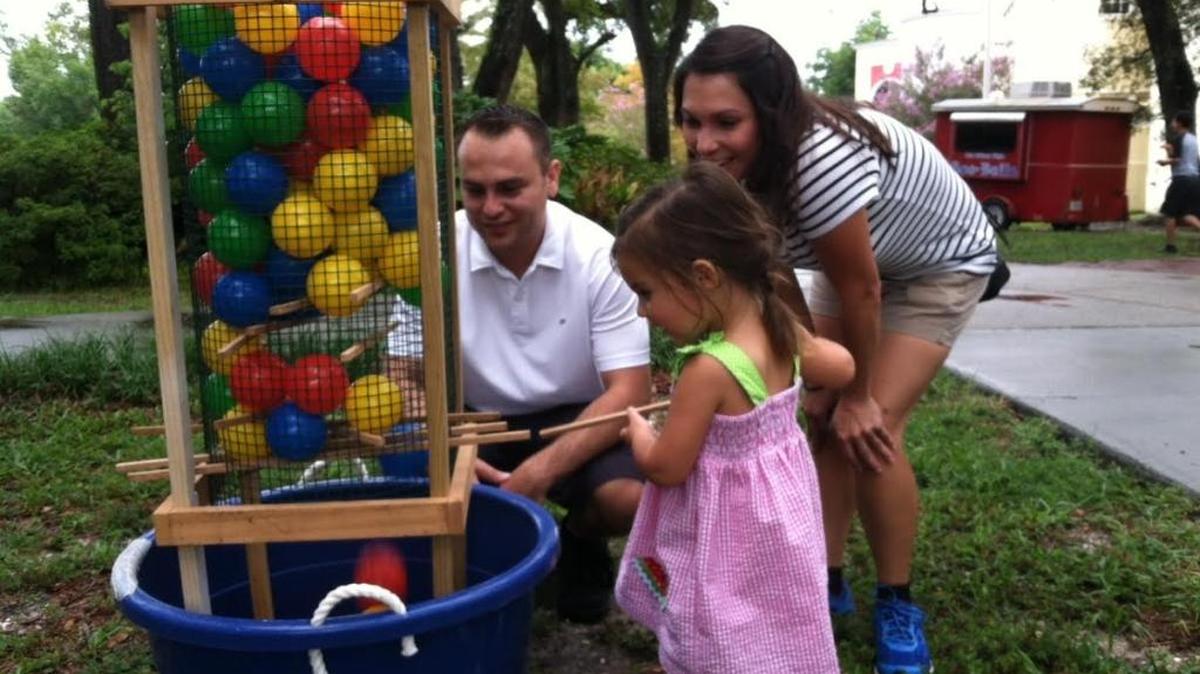 Lillian Manoram tries a game of Kerplunk during the Family Fun Night for first responders Sunday at Lynn Meadows Discovery Center. Her parents, Drew Manoram and Julia Sandoval, had come to Southern Bouncers' event to see their son perform in a skit.
