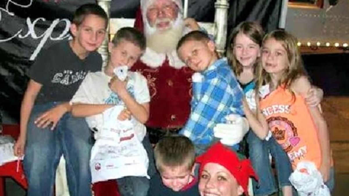 William, Kieler and Kristopher Young, from left, are shown last year with Santa, the three siblings they acquired by their father’s marriage, and one of Santa’s elves.