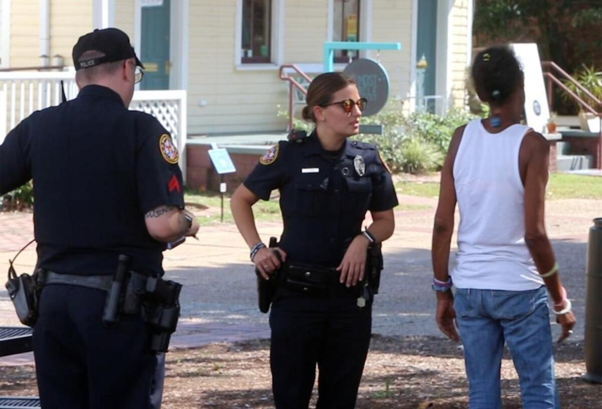 Biloxi patrolman Ashleigh Pack, center, and her partner, Patrolman John Lewis, talk to a woman in the Rue Magnolia district in September. Pack wound up in Glamour magazine as part of a report on the state of women in the United States.