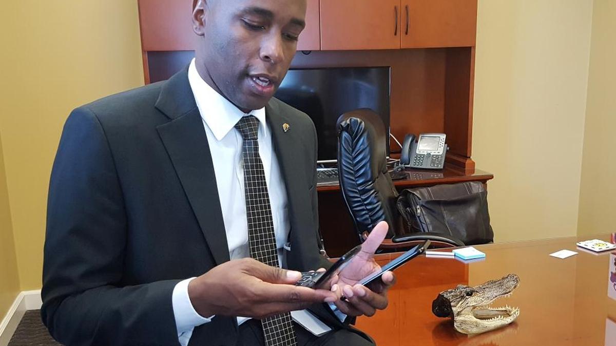 Moss Point Mayor Mario King holds a smartphone and flip phone at his office Thursday. He did a needs assessment, took up city employee smartphones and reissued flip phones, where needed, to save money.