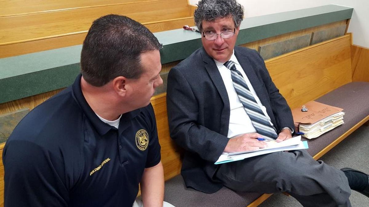 Former Jackson County prosecutor Mark Watts, right, and a county building official work out the details of a judge’s order. Watts is now Jackson County court judge.