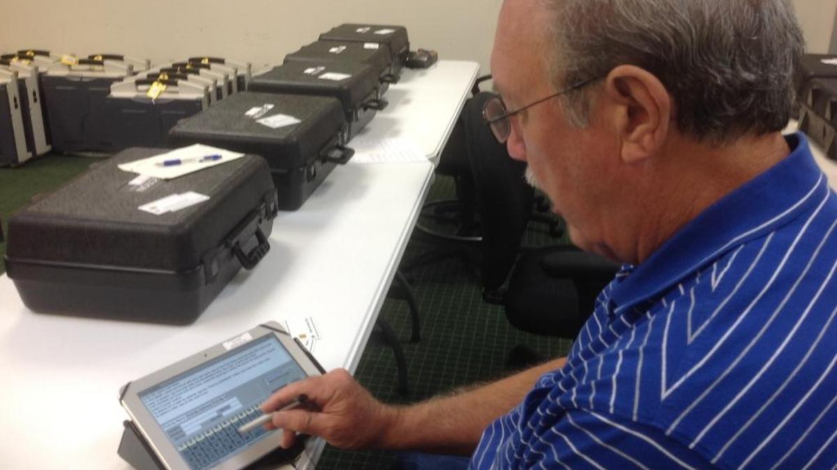 Danny Glaskox, chairman of the Jackson County Election Commission, demonstrates one of the 125 electronic poll books the county first put to use in the Nov. 6 mid-term election.