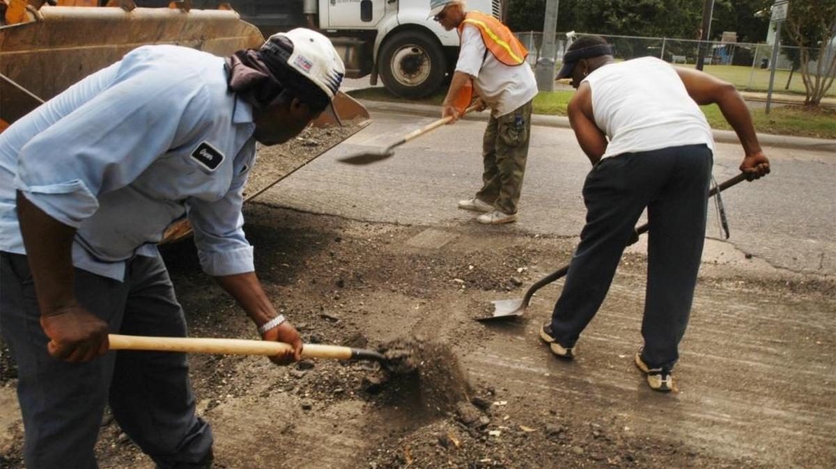 Workers with Pandle Asphalt Paving of Pascagoula prepare the south end of Market Street for repaving in 2003, when they kept one lane open and paved at night.