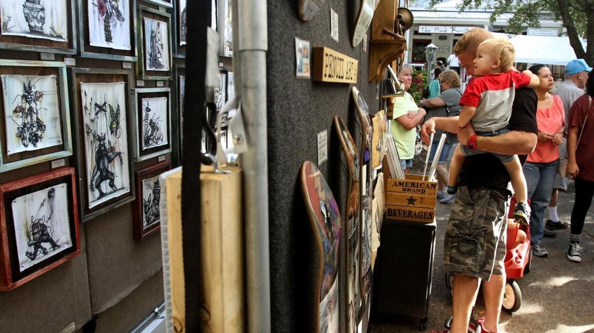 Visitors look at the art work of ballpoint pen artist Tai Taeoalii, left, skateboard artist Jeffrey St. Romain at the 38th annual Peter Anderson Festival on Saturday, November 5, 2016.
