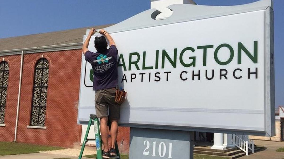 Arlington Heights Baptist Church is becoming Arlington Baptist as it takes over where Calvary Baptist had been on Market Street. John Lawrence of Rush Electric works on the new sign.