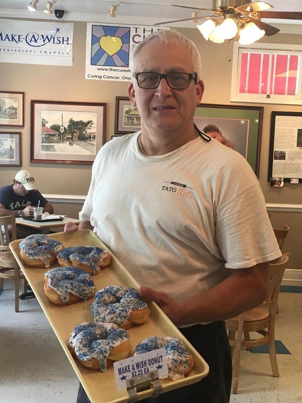 David Mohler, owner of TatoNut Donut Shop in Ocean Springs, shows off the new Make-A-Wish fundraising doughnut that will be for sale Saturday, which is World Wish Day.