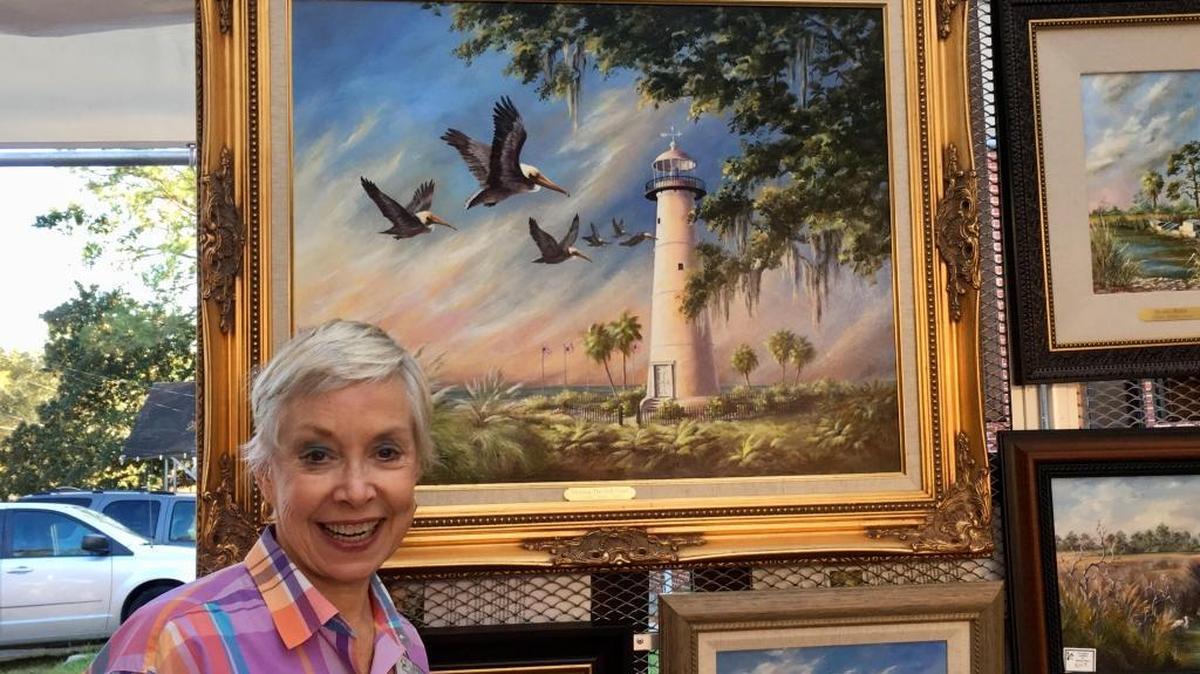 Artist Donna Peters of Crane Hill, Alabama, displays her oil paintings, which have a coastal theme, at the 39th annual Peter Anderson Arts and Crafts Festival in Ocean Springs on Sunday.
