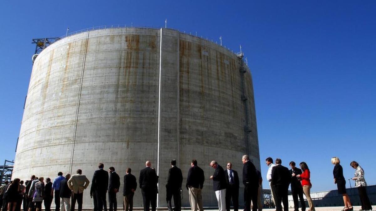 One of the two liquefied natural gas storage tanks dwarfs guests at the Gulf LNG Energy ribbon-cutting ceremony in 2011 in Pascagoula. Gulf LNG is moving ahead with permits to expand the plant for import and export capabilities.