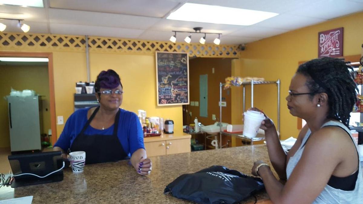 LaChelle’s Coffee and Conversation owner Donna Rogers, left, serves customer Kenya Evans.