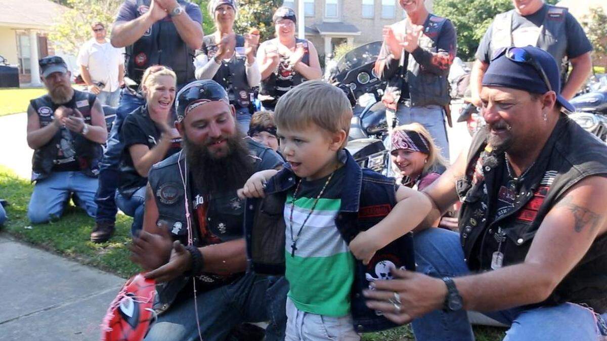 JOHN FITZHUGH/SUN HERALD Zander Saucier, 3, tries on a Bikers Against Child Abuse vest during a visit from the group at Zander's house in Gulfport on Saturday May 7, 2015.