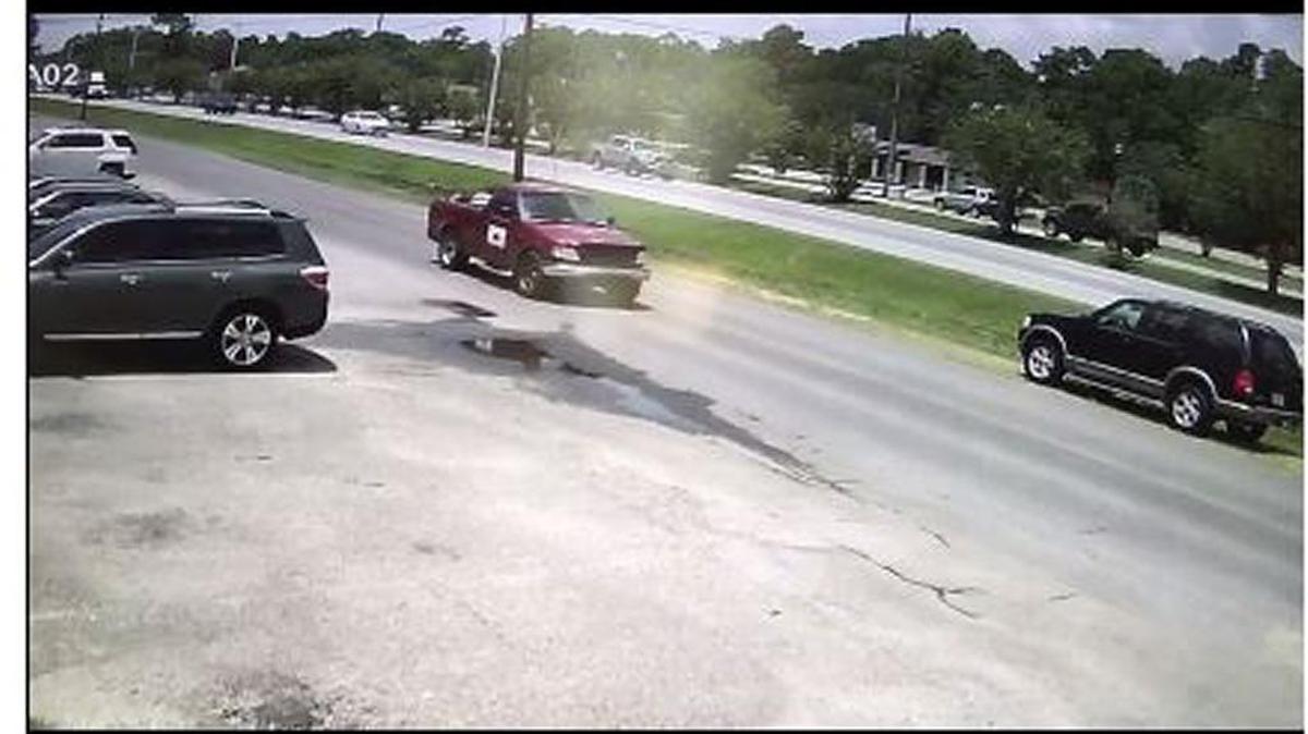 Surveillance camera caught someone in a red pickup truck taking a utility trailer from a business in Ocean Springs in broad daylight.