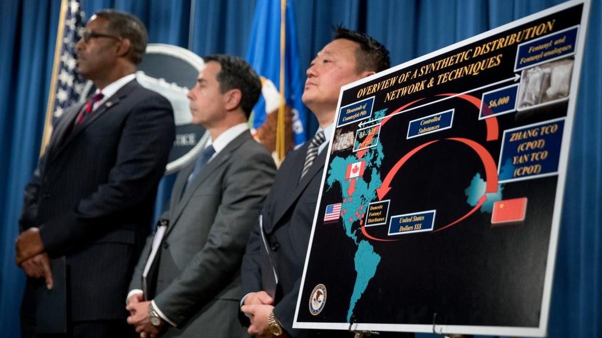 Law enforcement officials appear before a drug distribution poster during a news conference at the Justice Department in Washington, Tuesday, Oct. 17, 2017, to announce the indictments of two Chinese fentanyl trackers in the fight against opiate substances from entering the United States.