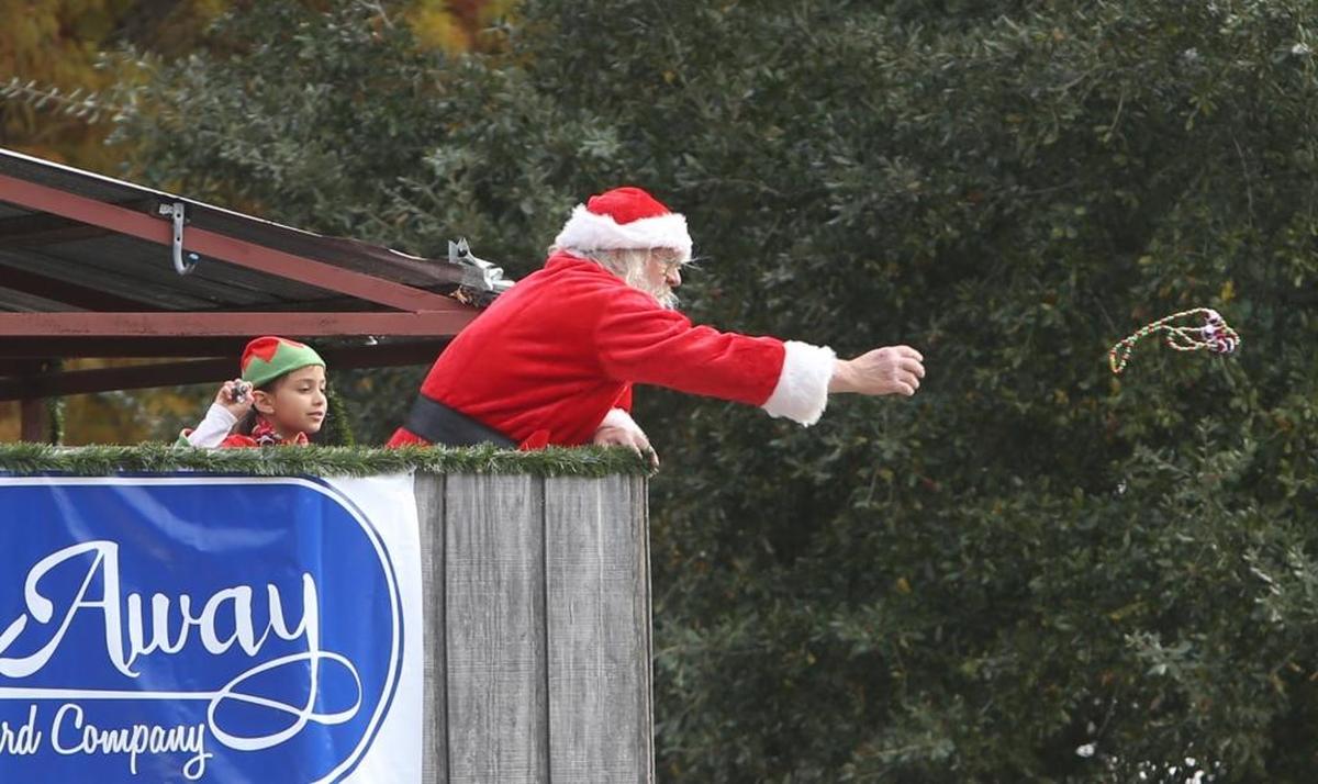 Ronald Winnert tosses beads to the crowd during the Bay St. Louis Christmas parade Saturday, Dec. 3, 2016.