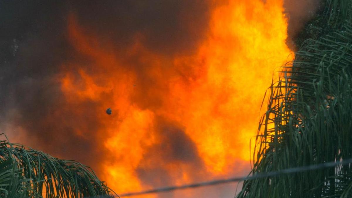 Flames erupt from a house on River Road, where two people were believed to have been shot and killed in Jefferson, Louisiana, on Nov. 7, 2016.