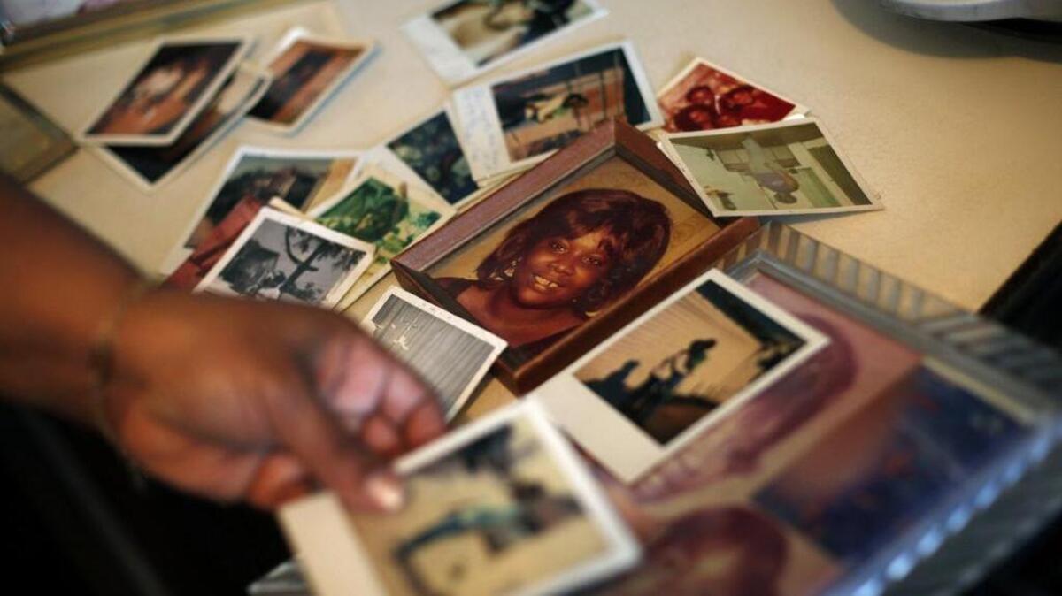 In this Tuesday, March 12, 2013 photo, Brenda Gordon looks at photos of her mother, Carol Alford, at her apartment in Los Angeles. Alford was allegedly murdered by Samuel Little in 1987.