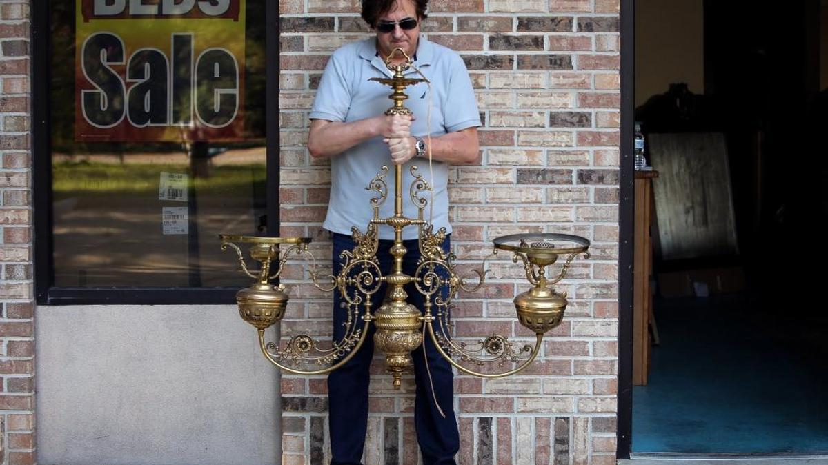 Mike Haydel holds the remaining light fixture that was not stolen from his Gulfport business on Thursday. He had three of the fixtures rewired, polished and restored for a bar and grill his brother plans to open next year in downtown Gulfport. Two of the three were stolen, along with other items, and he is hoping to be reunited with them.