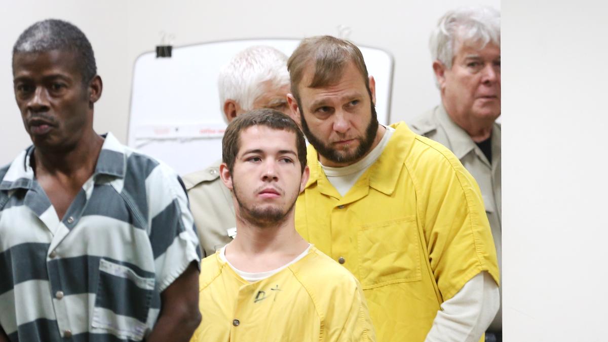 Todd Harrell, third from left, enters Judge T. Larry Wilson’s Jackson County courtroom on Monday, August 6, 2018, after being charged with introducing contraband into a correctional facility.