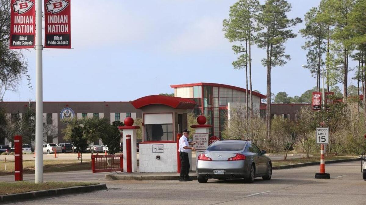 Swetman Security employee Jim Phelps talks to a visitor at the Biloxi High School/Biloxi Junior High campus gate on Friday.
