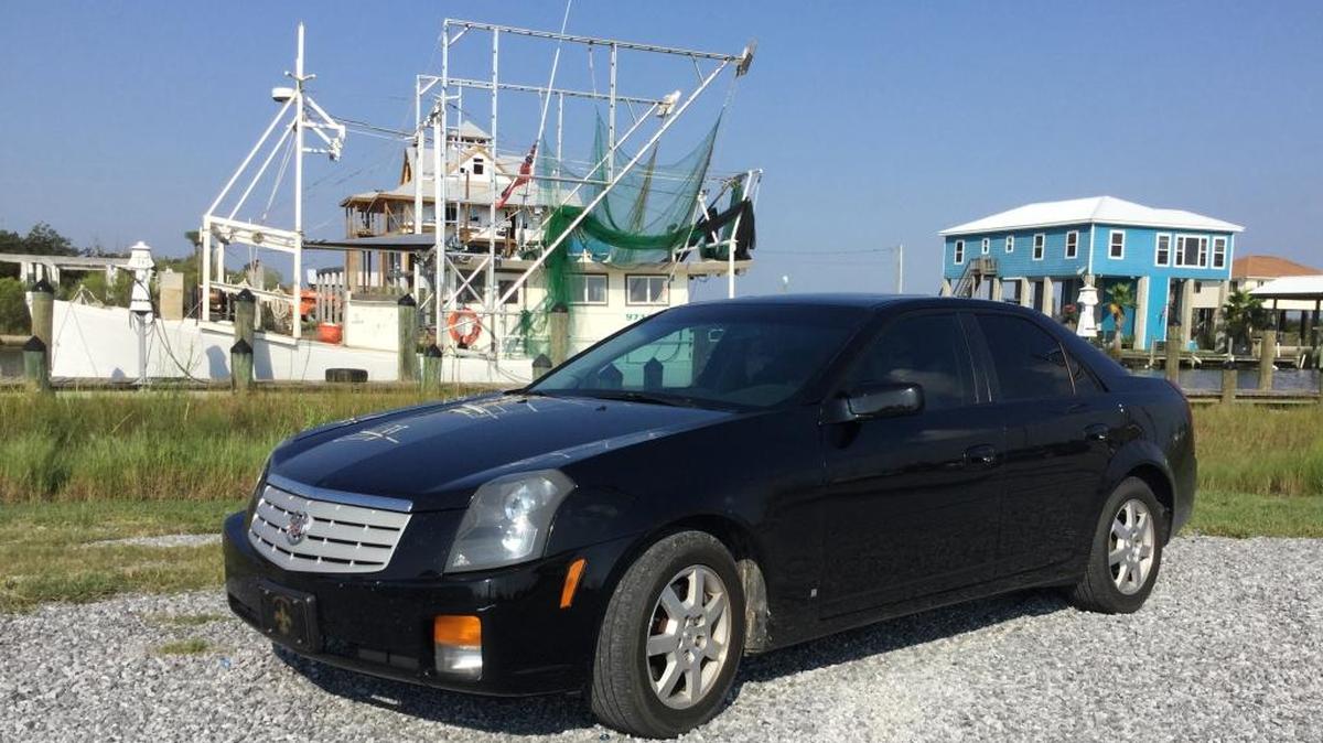 A 2007 Cadillac CTS poses with a fishing trawler at Bayou Caddy in Hancock County.
