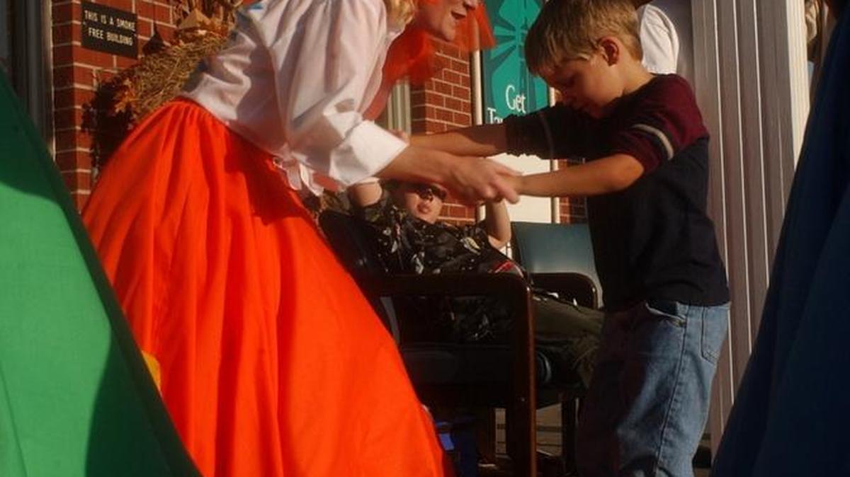 Jodi Wein dances with her son, Joshua Daniels, 6, outside the Hancock Bank in Long Beach before the parade starts to kick off a previous Cruisin' the Coast.