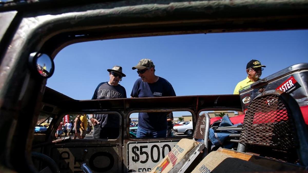 Car fans gather around a 1961 Willys Jeep Wagon with the roof removed during Cruisin' The Coast on Saturday, October 8, 2016, at the Edgewater Mall. Sunday is the last day of Cruisin' The Coast.