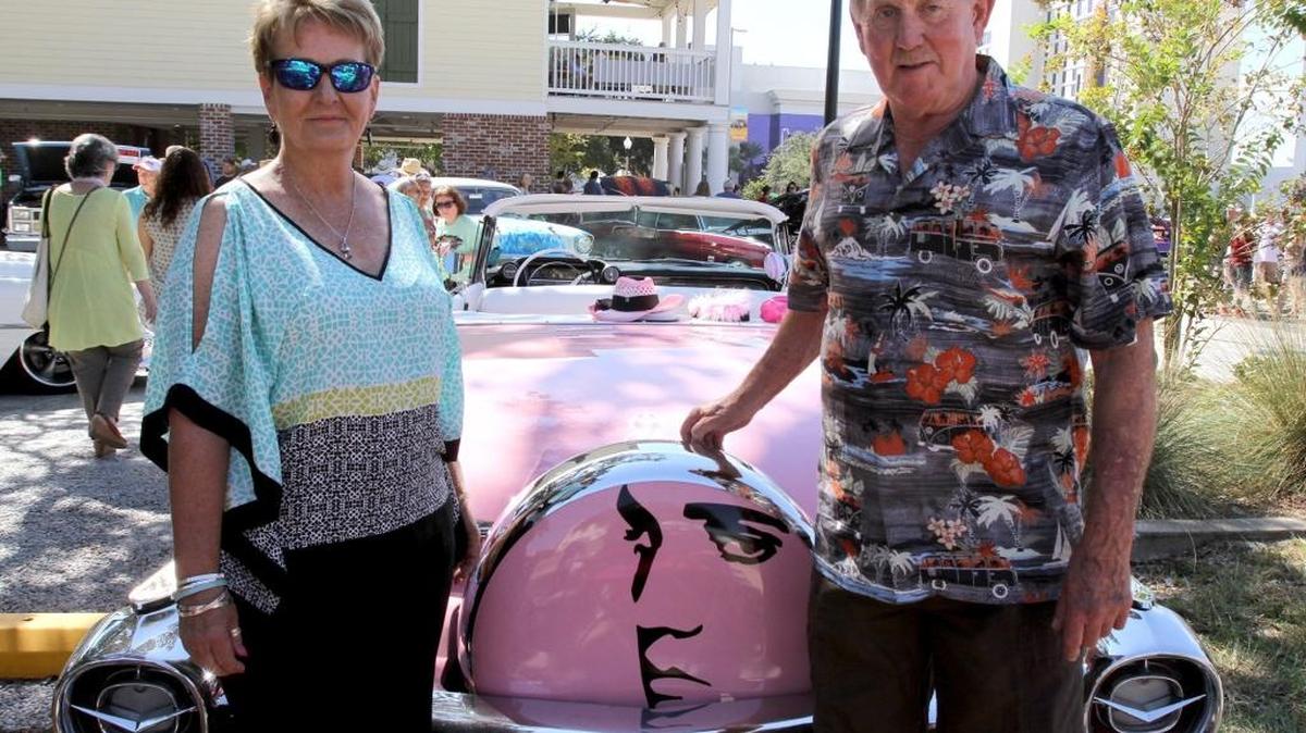 Brigid and Don Maddox stand next to their 1959 Cadillac Convertible featuring the King of Rock and Roll.