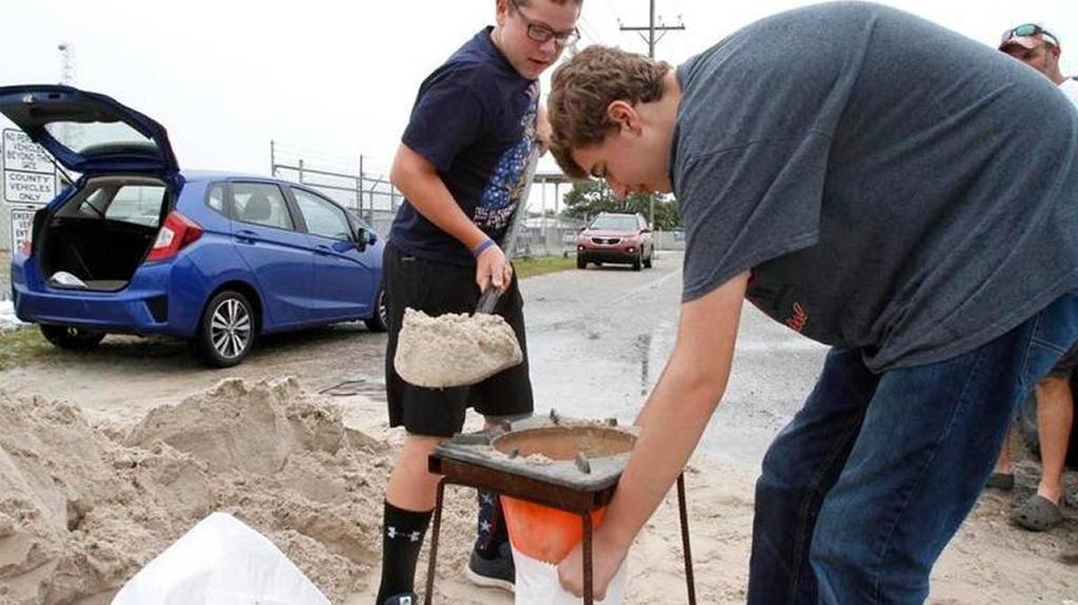 Chris Harris and Grant Whittet team up to fill bags of sand earlier this year at the Lorraine Road Work Center on Highway 605.