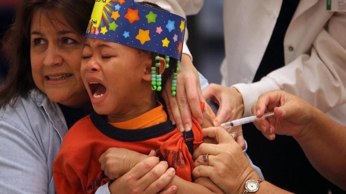 Kindergarten teacher Naomi Foster holds Latasha Johnson as she gets an H1N1 flu shot at Gorenflo Elementary. The Mississippi State Department of Health reminds parents that state law requires kids to be immunized against childhood diseases in order to enter public or private school, Head Start or day care.