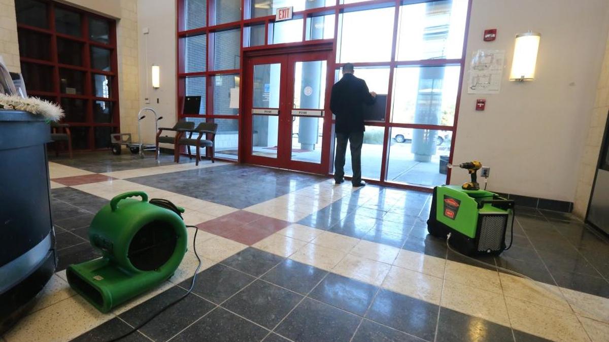 Biloxi High School Principal Marcus Boudreaux puts up a sign on Monday, Dec. 11, 2017 near the front entrance directing visitors to the west entrance of the school while they clean up the mess from a sprinkler system malfunction over the weekend.