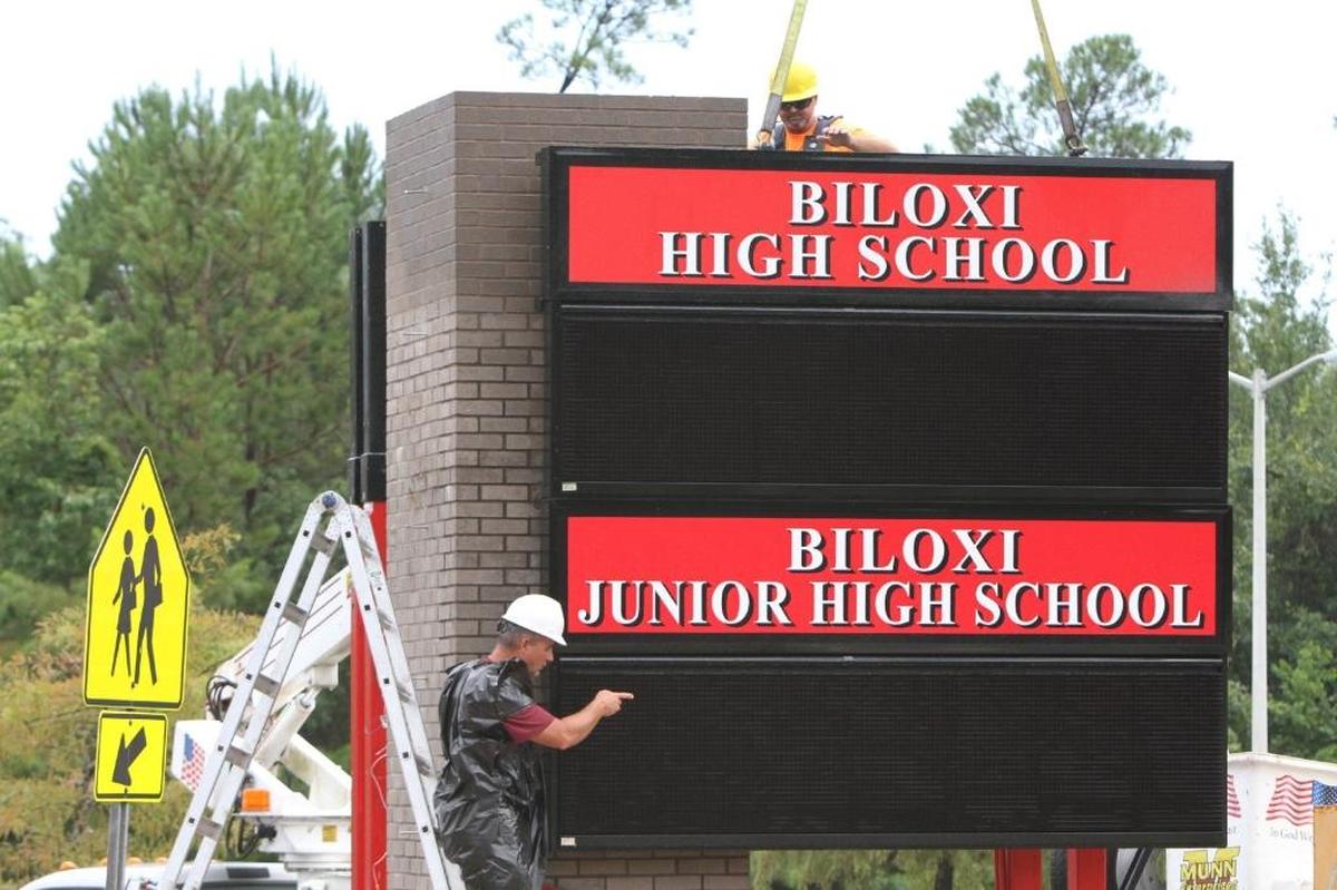 Construction workers install the new sign for Biloxi Junior High School and High School on Tuesday, July 25, 2017.