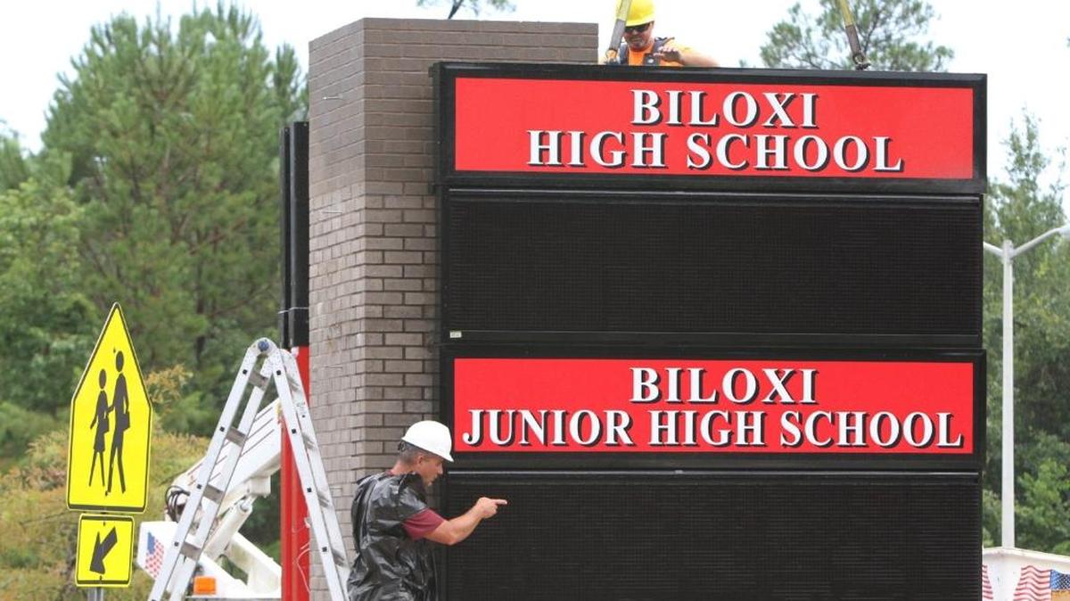 Construction workers install the new sign for Biloxi Junior High School and High School on Tuesday, July 25, 2017.