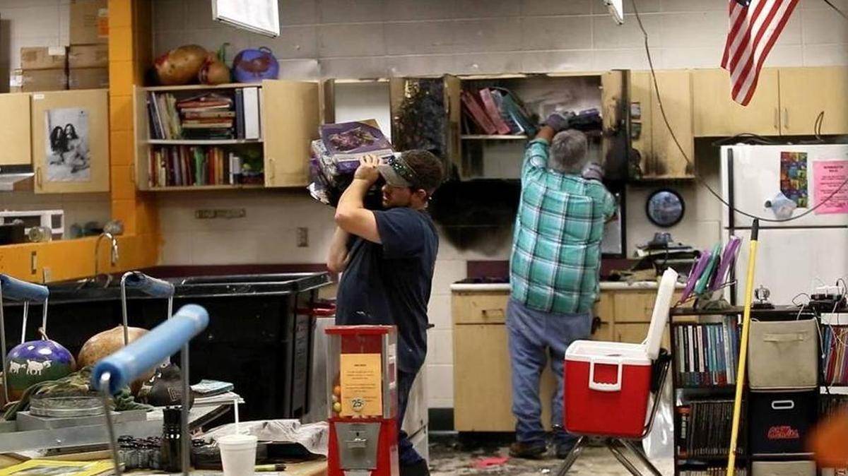 Members of Servpro, a Hancock business specializing in water- and fire-damage cleanup, clean the classroom in which there was a small fire at Hancock County Middle School early Monday, January 23, 2016. The fire triggered the sprinkler system, which ran for nearly four hours, flooding numerous classrooms.