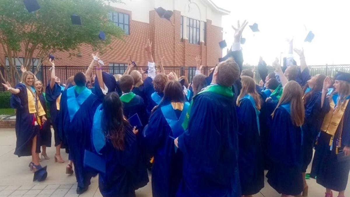 St. Patrick High School Graduates celebrate landmark with traditional tossing of caps.