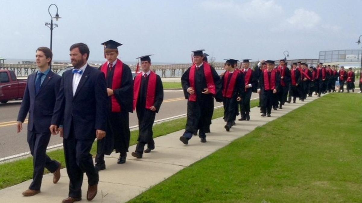 Patrick McGrath, principal, and Erich Hoffer, director of guidance, lead graduates from the St. Stanislaus College campus to Our Lady of the Gulf Catholic Church for commencement exercises Saturday, May 27, 2017.