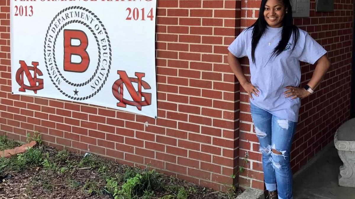 Cashawn Hightower, now 23, stands in front of school in the Harrison County School District, where she works as a counselor. Hightower credits the district for getting her back on her feet when she was homeless, pregnant and in high school.