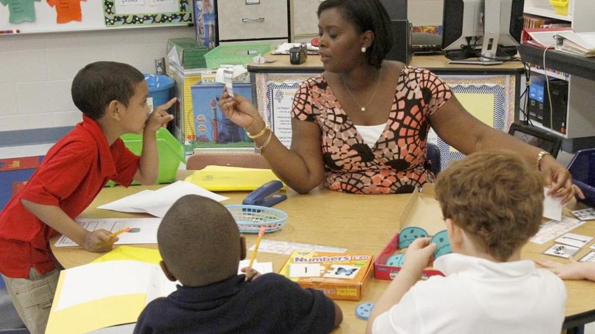Martin Bluff Elementary School kindergarten teacher Shaun Mims helps her students with flash cards at the Gautier school in September 2013.