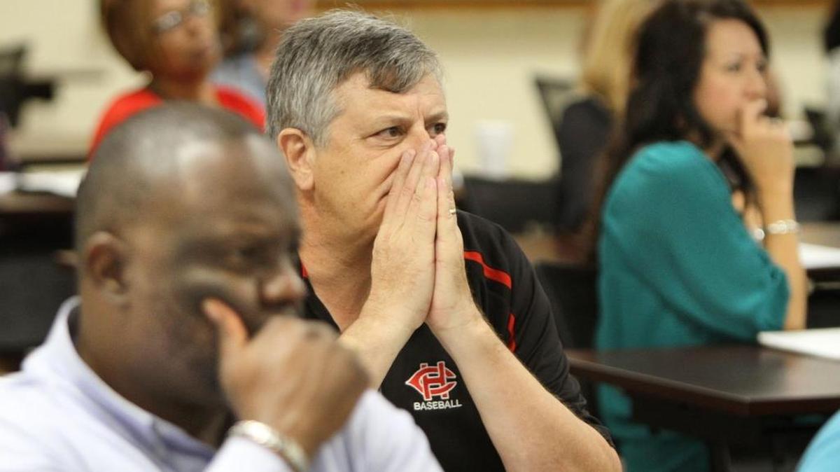 Leonardo Scott, left, and Mike David of Harrison Central High School and Amy Thibodeaux of North Woolmarket Elementary listen to the 911 tape from the Columbine shooting during a safety and security training session at the Harrison County School District Center for Excellence in Gulfport on Monday.